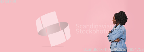 Image of African-american woman portrait isolated on pink studio background with copyspace