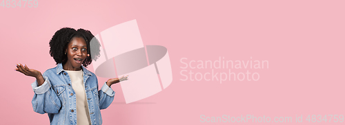 Image of African-american woman portrait isolated on pink studio background with copyspace
