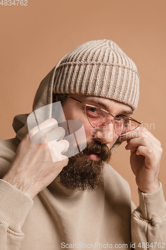 Image of Portrait of Caucasian man in glasses and hat isolated on light background.