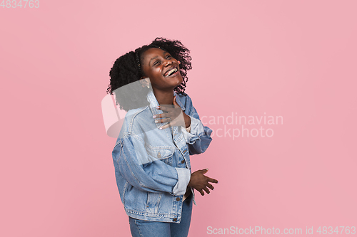 Image of African-american woman portrait isolated on pink studio background with copyspace