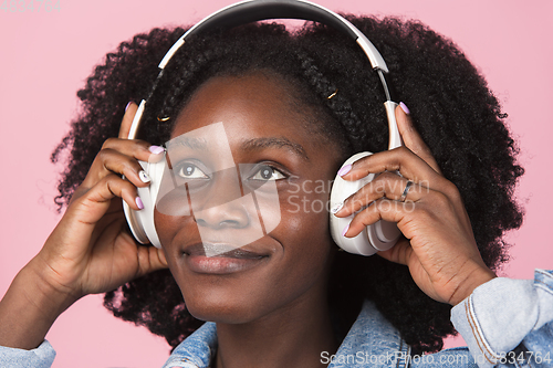 Image of African-american woman portrait isolated on pink studio background with copyspace