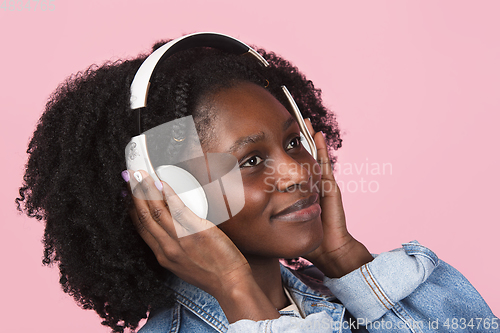Image of African-american woman portrait isolated on pink studio background with copyspace