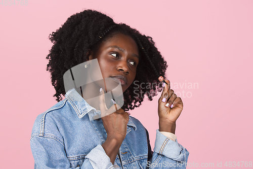 Image of African-american woman portrait isolated on pink studio background with copyspace