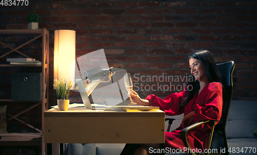 Image of Young Caucasian woman talking with friend online through laptop.