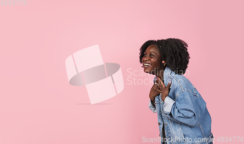 Image of African-american woman portrait isolated on pink studio background with copyspace