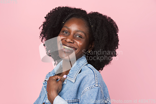 Image of African-american woman portrait isolated on pink studio background with copyspace