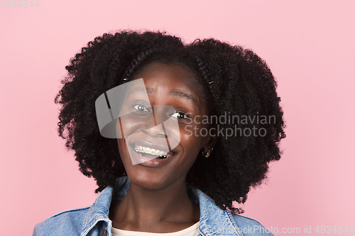 Image of African-american woman portrait isolated on pink studio background with copyspace