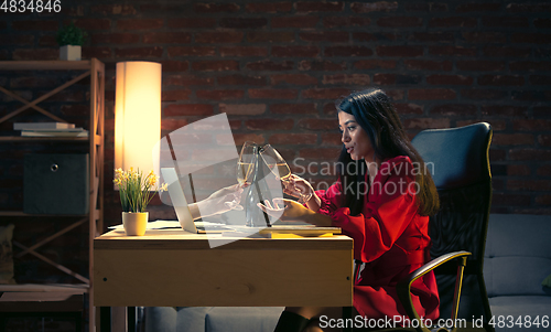 Image of Young Caucasian woman talking with friend online through laptop.