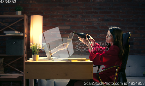 Image of Young Caucasian woman talking with friend online through laptop.