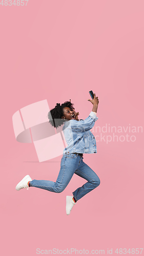 Image of African-american woman portrait isolated on pink studio background with copyspace