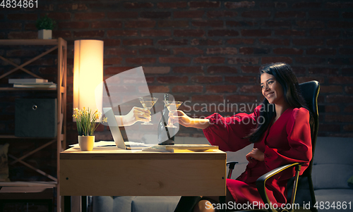 Image of Young Caucasian woman talking with friend online through laptop.