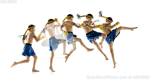 Image of Little boy exercising thai boxing on white background. Fighter practicing, training in martial arts in action, motion. Evolution of movement, catching moment.