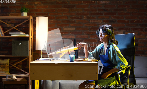 Image of Young Caucasian woman during online cooking lesson through laptop.