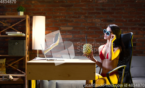 Image of Young Caucasian woman talking with friend online through laptop.