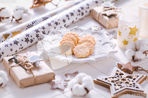 Image of Christmas time, homemade cookies with ornaments and winter decorations in white