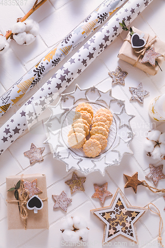 Image of Christmas time, homemade cookies with ornaments and winter decorations in white