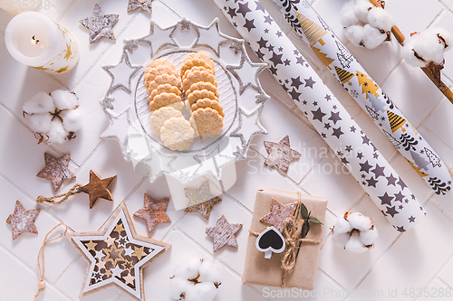 Image of Christmas time, homemade cookies with ornaments and winter decorations in white