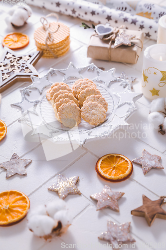 Image of Christmas time, homemade cookies with ornaments and winter decorations in white