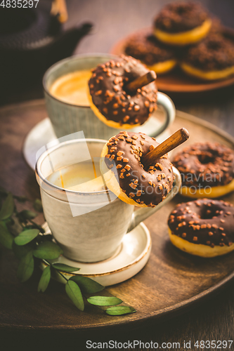 Image of Two cups of Caffe Americano with small chocolate donuts