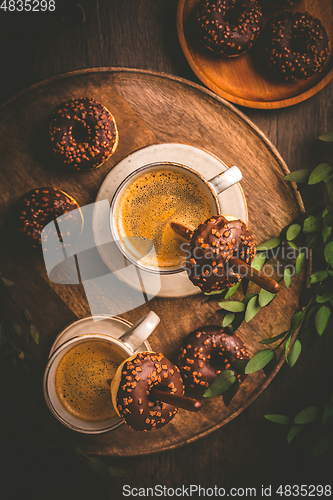 Image of Two cups of Caffe Americano with small chocolate donuts