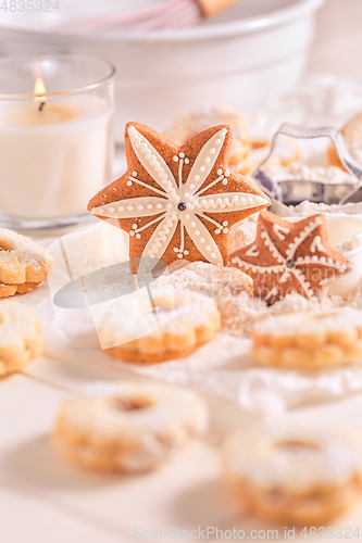 Image of Homemade Christmas gingerbread and cookies with baking ingredients in white