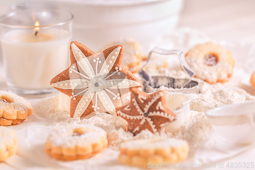 Image of Homemade Christmas gingerbread and cookies with baking ingredients in white