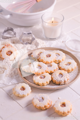 Image of Homemade Christmas cookies with baking ingredients in white