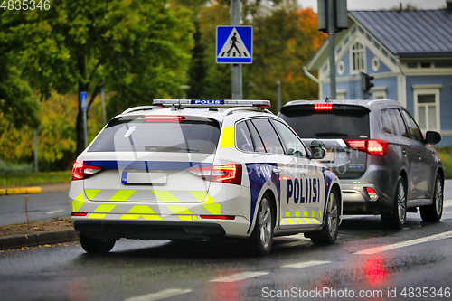 Image of Police Vehicle Behind Car