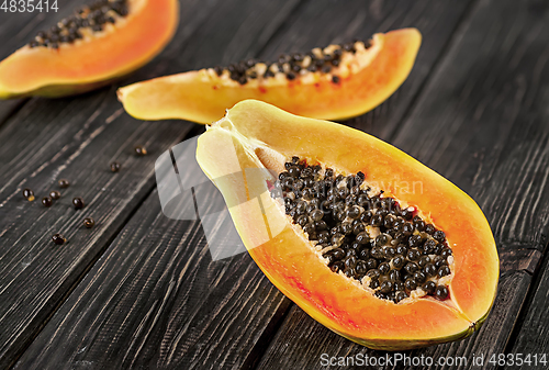 Image of Several pieces of ripe papaya on a wooden table