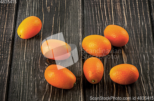 Image of Several ripe kumquats on a wooden table