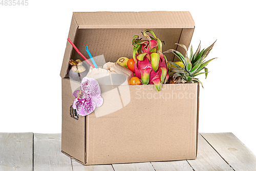 Image of Tropical fruits in cardboard box isolated on white