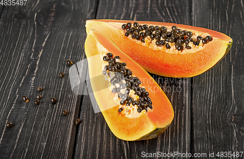 Image of Two pieces of ripe papaya on a wooden table