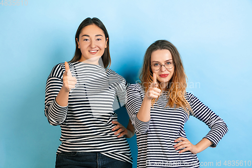 Image of Young emotional women on gradient blue background
