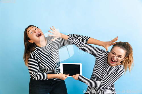 Image of Young emotional women on gradient blue background