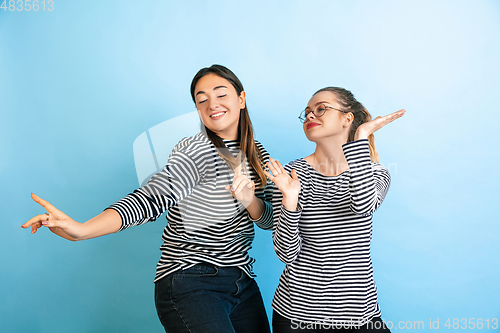 Image of Young emotional women on gradient blue background