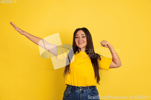 Image of Caucasian woman\'s portrait isolated on yellow studio background