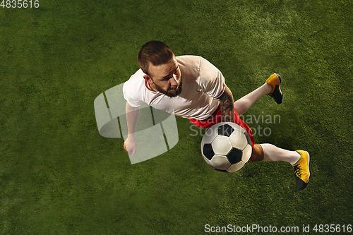 Image of Top view of caucasian football or soccer player on green background of grass