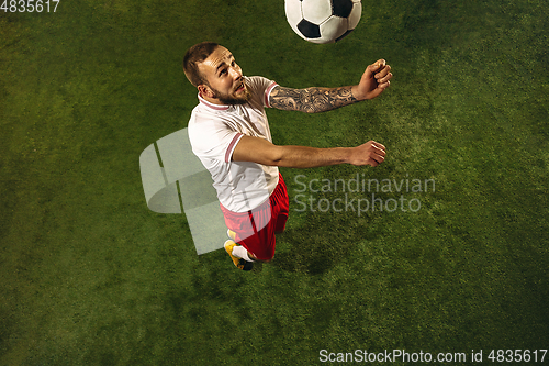 Image of Top view of caucasian football or soccer player on green background of grass