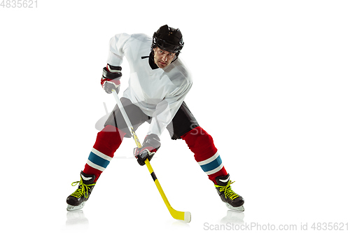 Image of Young male hockey player with the stick on ice court and white background