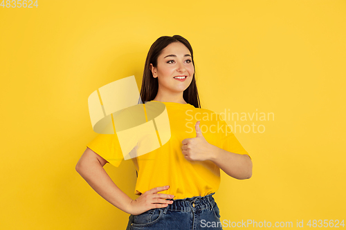 Image of Caucasian woman\'s portrait isolated on yellow studio background