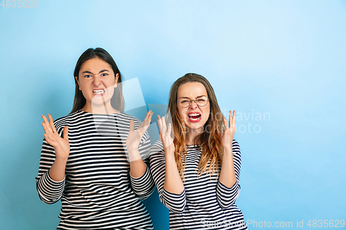 Image of Young emotional women on gradient blue background