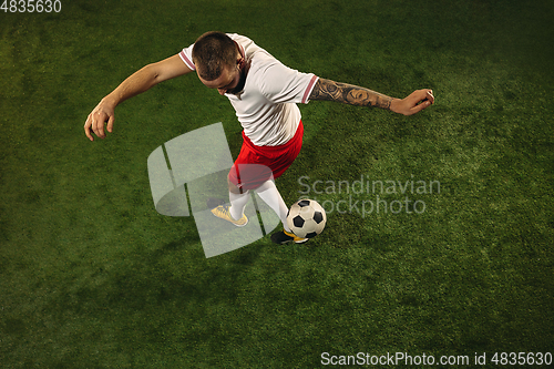 Image of Top view of caucasian football or soccer player on green background of grass