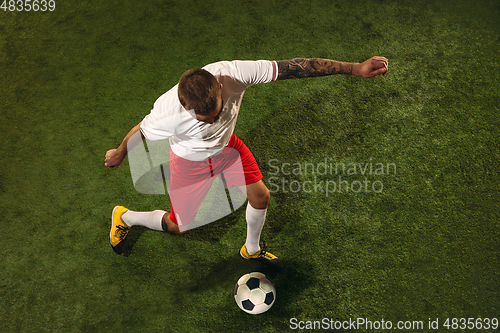 Image of Top view of caucasian football or soccer player on green background of grass