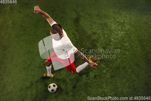 Image of Top view of caucasian football or soccer player on green background of grass