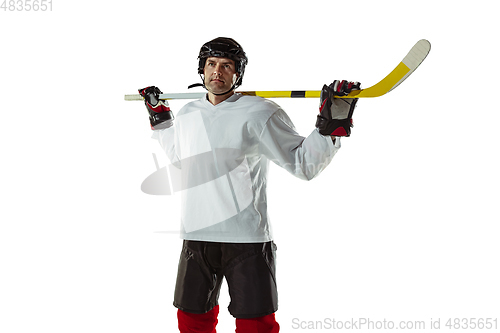 Image of Young male hockey player with the stick on ice court and white background