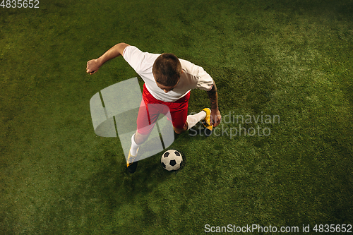 Image of Top view of caucasian football or soccer player on green background of grass