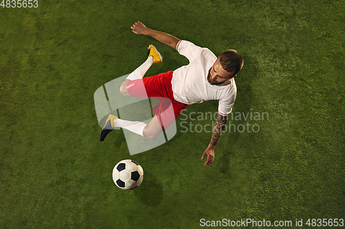 Image of Top view of caucasian football or soccer player on green background of grass