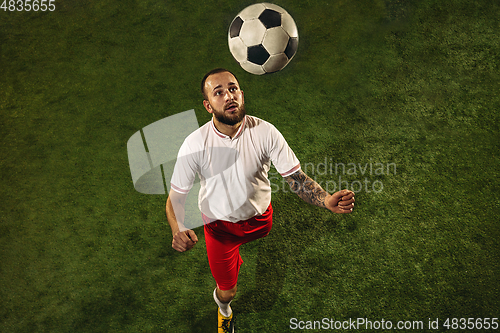 Image of Top view of caucasian football or soccer player on green background of grass