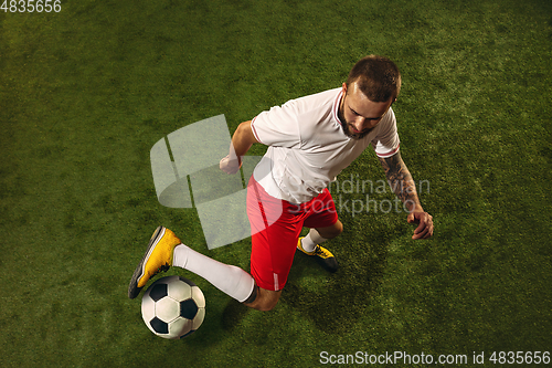 Image of Top view of caucasian football or soccer player on green background of grass