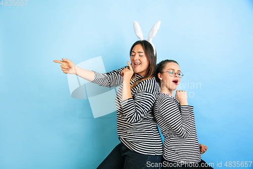 Image of Young emotional women on gradient blue background